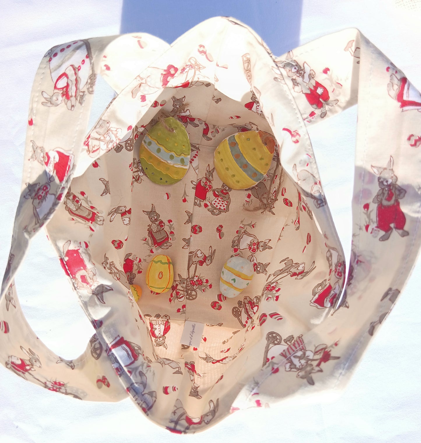 Sac cabas pour la chasse aux œufs de Pâques pour les enfants sages, fond beige, lapins et œufs.