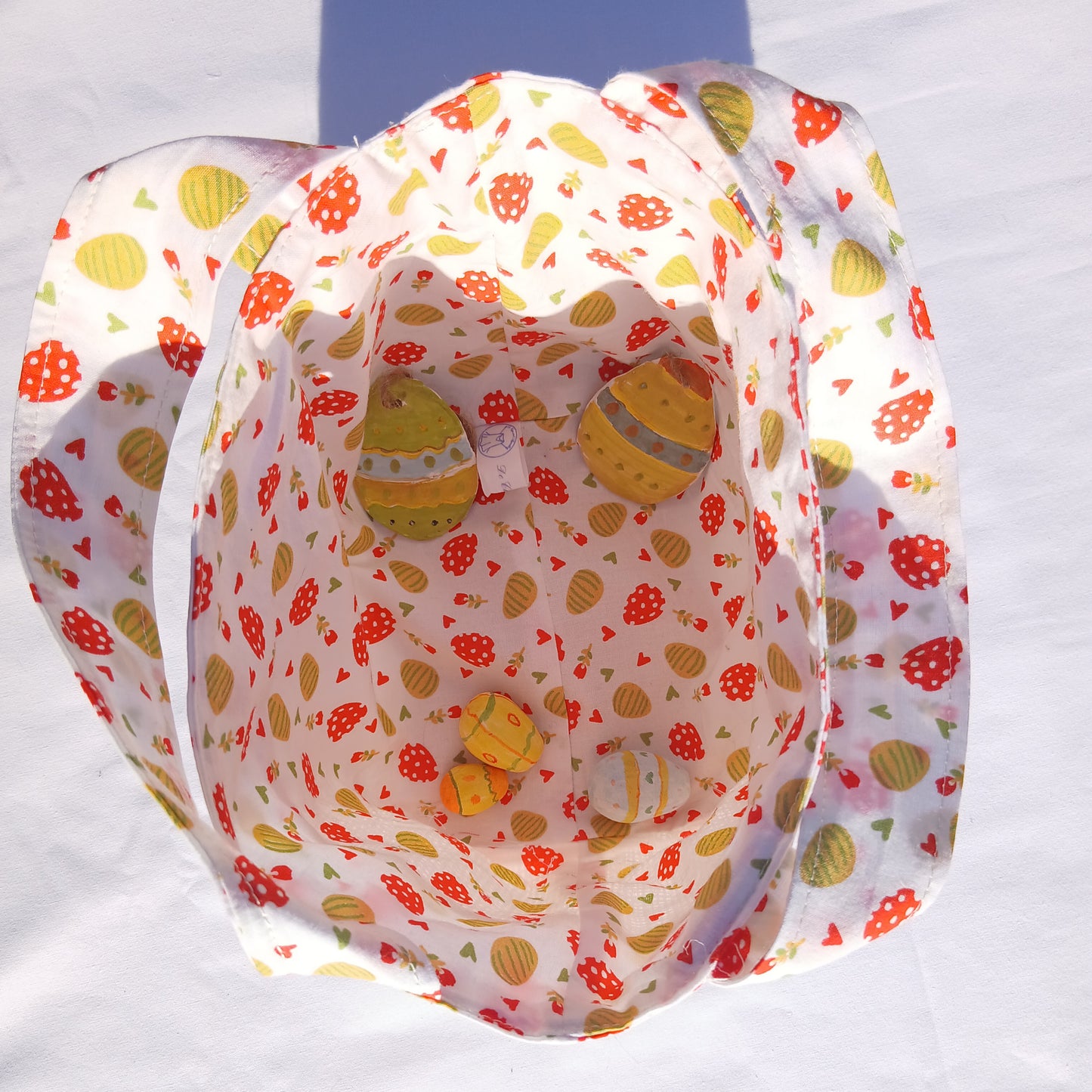 Sac cabas pour la chasse aux œufs de Pâques pour les enfants sages, fond blanc, œufs oranges et jaune.
