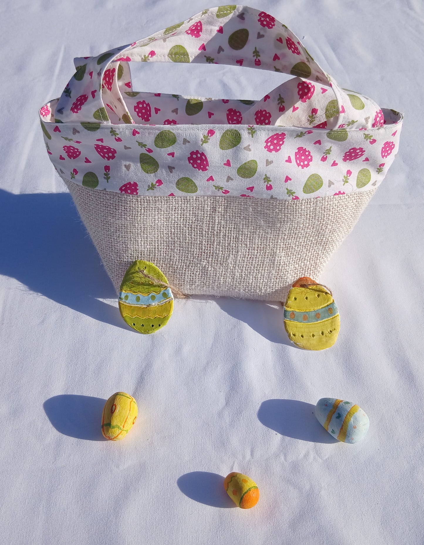 Sac cabas pour la chasse aux œufs de Pâques pour les enfants sages, fond blanc, œufs roses et verts.