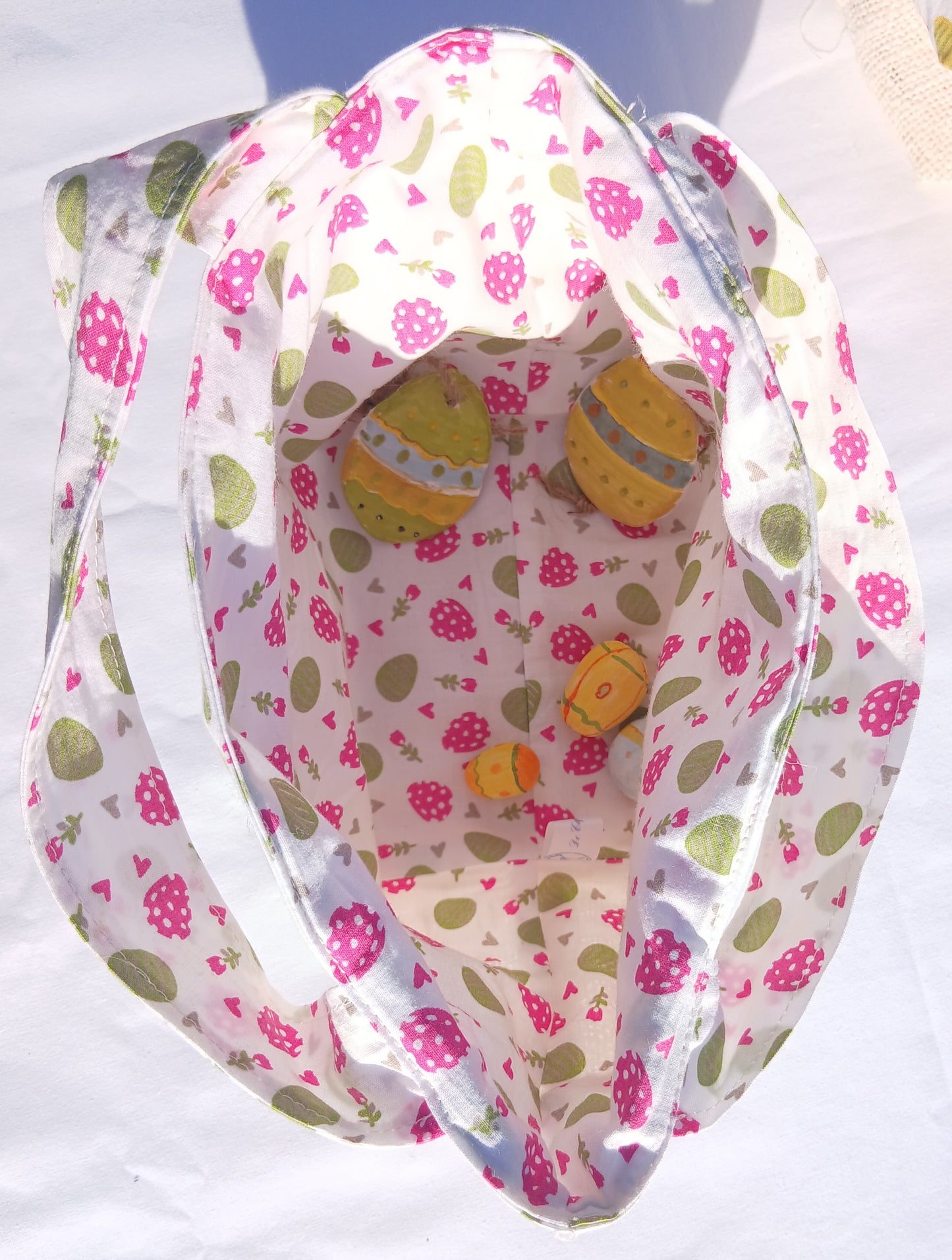 Sac cabas pour la chasse aux œufs de Pâques pour les enfants sages, fond blanc, œufs roses et verts.